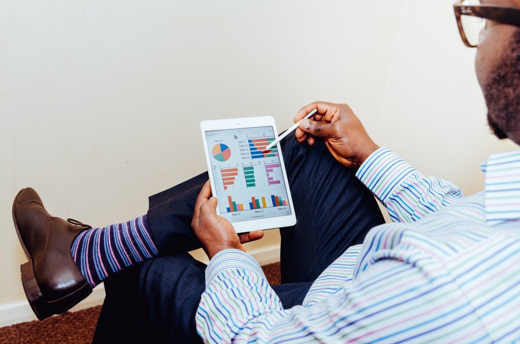 Man op ipad bekijkt grafieken