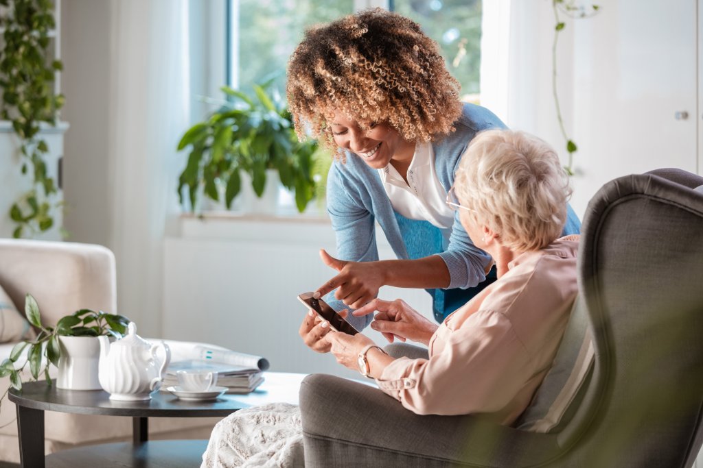 verzorgster-oudevrouw-uitleg-smartphone