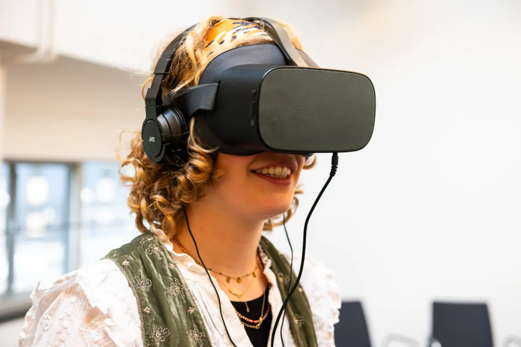 Vrouw bekijkt de wereld Met andere ogen via een VR-bril tijdens de Sigra conferentie Diversiteit en Inclusie 2023.